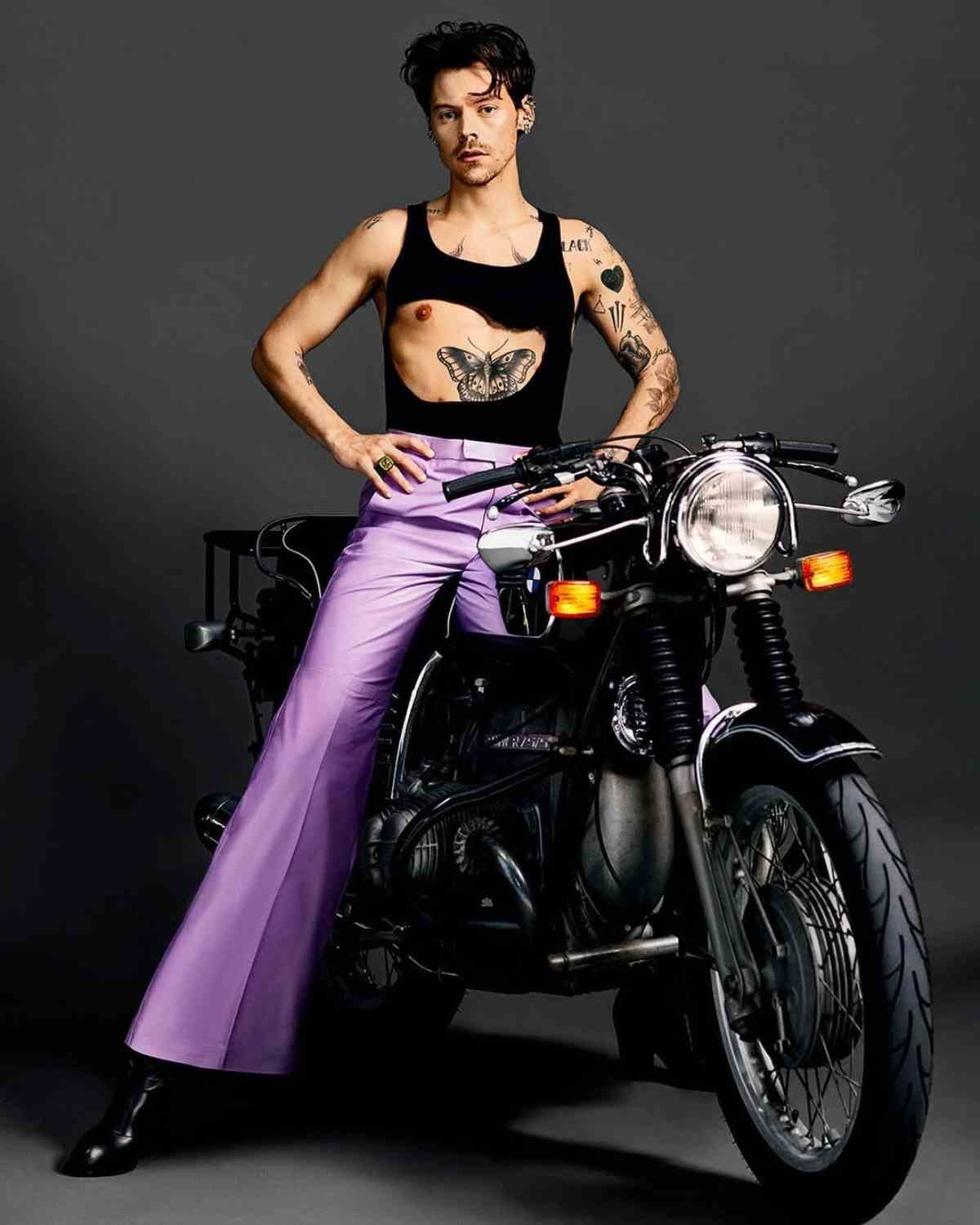 harry styles in posa con un look genderless su una moto