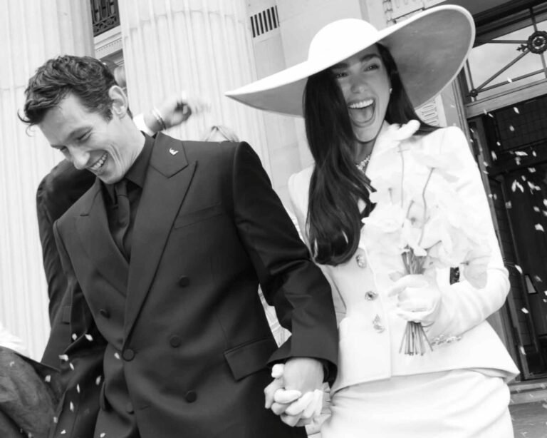 dua lipa e callum turner appena sposi all'uscita da un edificio di londra