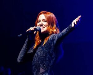la cantante noemi sorride mentre canta esibendosi su un palco